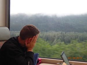 Chris looking out of the train's window, enjoying the scenery.